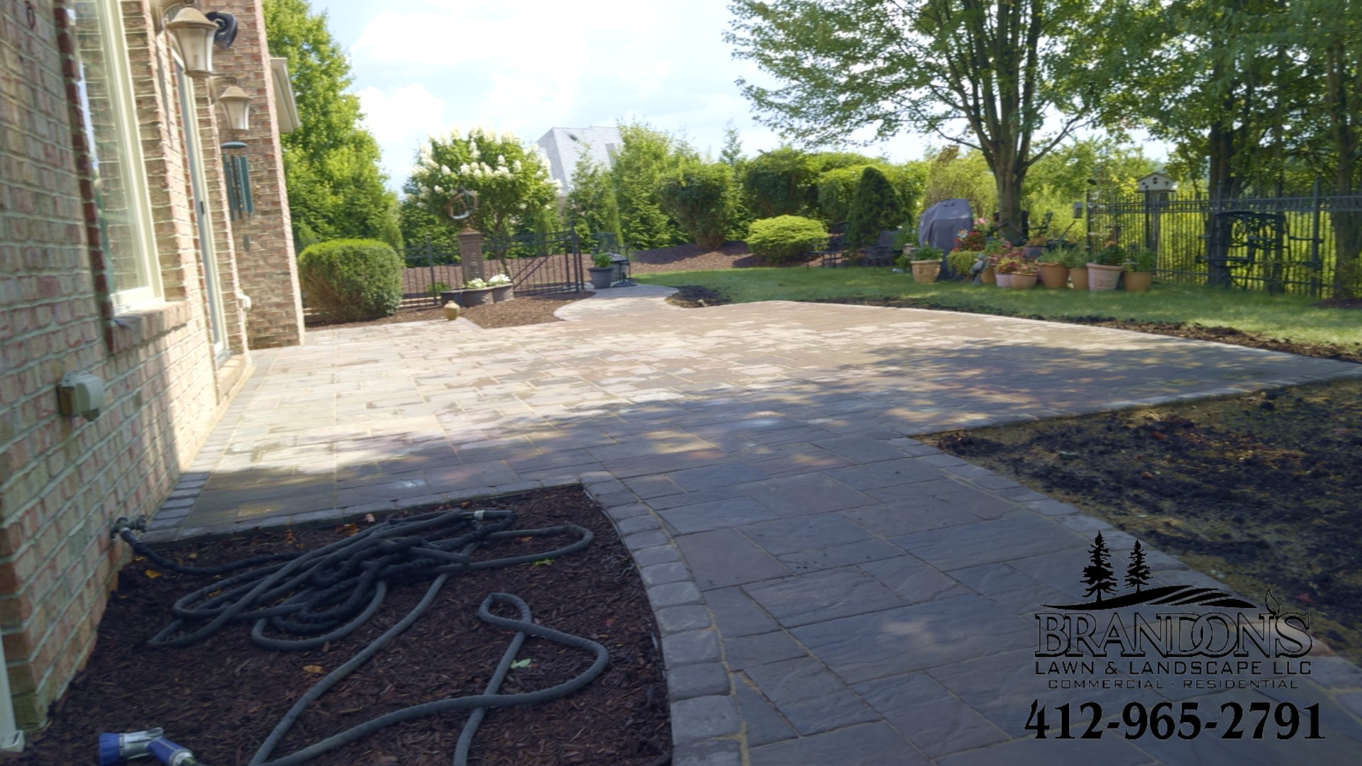 Expansive backyard patio with curved border design and smooth transition to landscaped yard