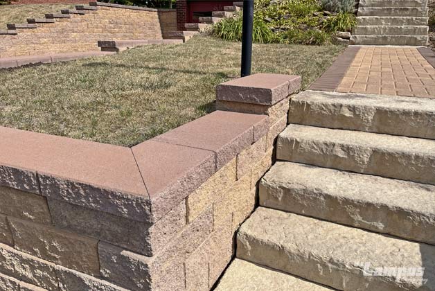 Close-up of retaining wall corner and steps showing block texture and capstone finish