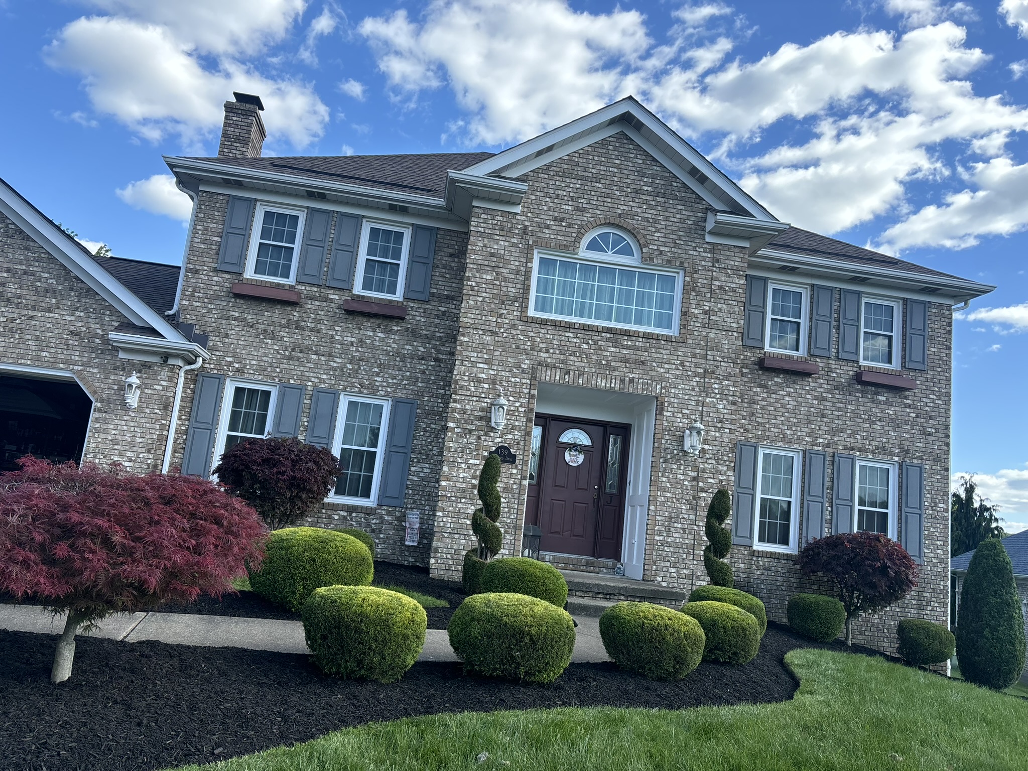 Front home landscape refresh with trimmed shrubs, fresh mulch, and clean curb appeal