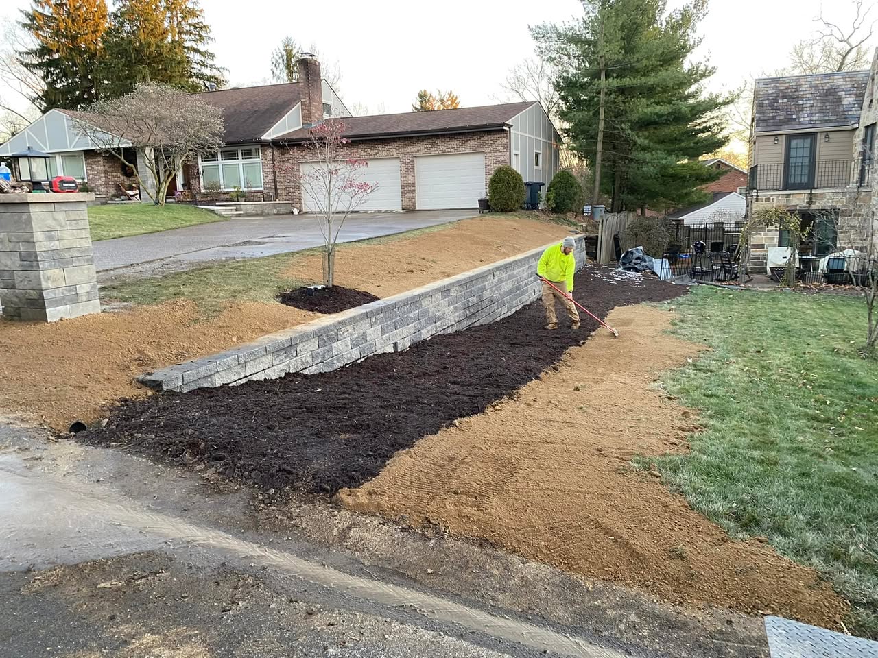 Front yard retaining wall with fresh mulch bed and grading transition