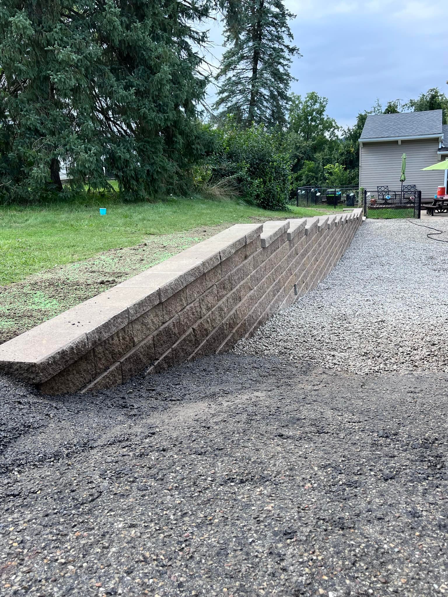 Long retaining wall installation with gravel base and clean linear construction
